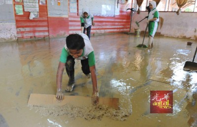 达瑙国小学生在水灾后，纷纷回校清理被泥水蹂躏的校园与课室。