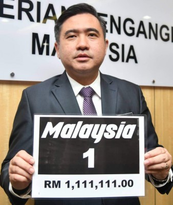 陆兆福展示MALAYSIA 1”号码，得标价为111万1111令吉，创下陆路交通局车牌竞标纪录。